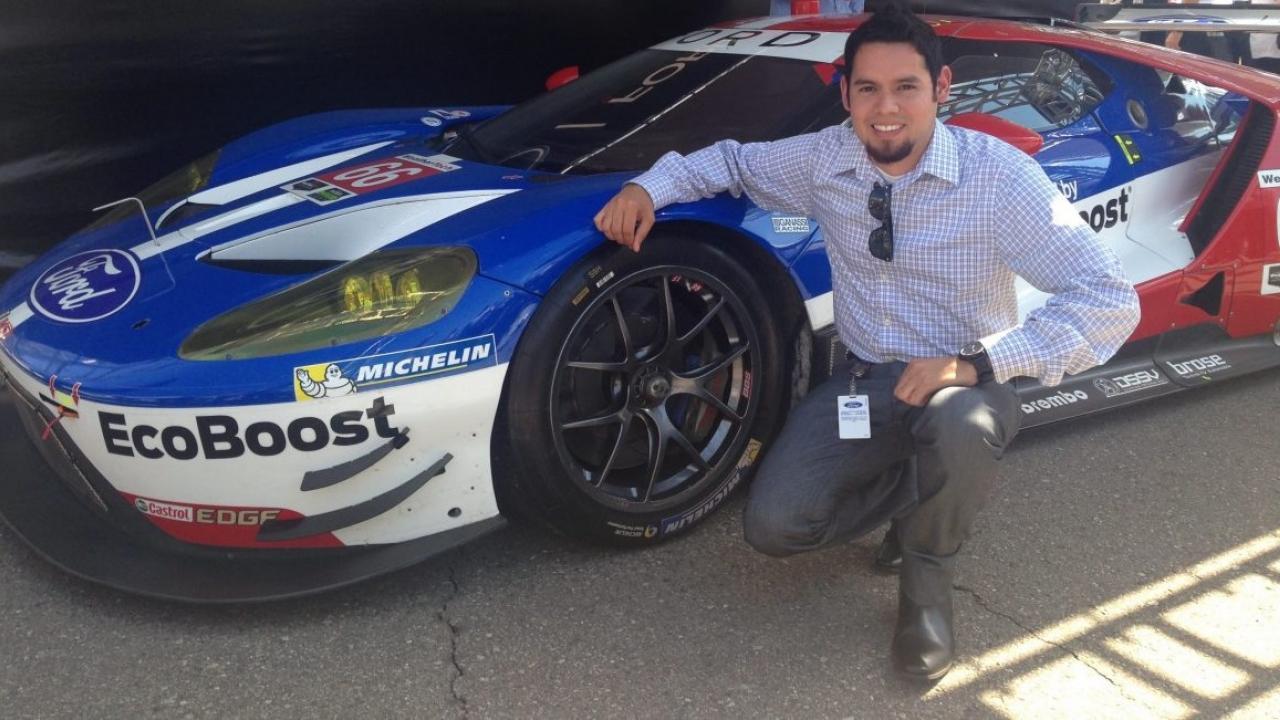 Jose Velazquez in front of a Ford Racing Vehicle